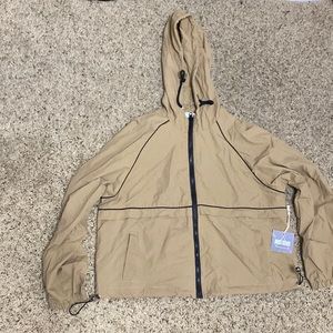 Tan brown windbreaker, kinda cropped and does have pockets.